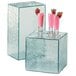 A Cal-Mil acrylic rectangular riser with a glass cube on top filled with pink drinks and strawberries.