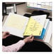 A person holding a Smead yellow file folder over a yellow book.