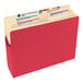 A close-up of a red Smead file folder with a label on the tab.