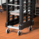 A black Rubbermaid ProServe steam table pan rack on wheels.