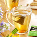 A glass mug of Bigelow Perfectly Mint tea with a tea bag in it.