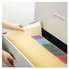 A person putting a Smead file folder into a file drawer.