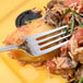 A Chef & Sommelier stainless steel dinner fork on a plate of pasta with vegetables.