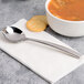 A Chef & Sommelier stainless steel soup spoon in a bowl of soup with crackers.