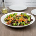 A vegetable salad in a white 10 Strawberry Street Whittier coupe bowl.