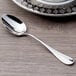 A Chef & Sommelier stainless steel demitasse spoon on a table.