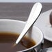 A Chef & Sommelier stainless steel demitasse spoon in a cup of coffee.