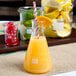 An American Metalcraft Erlenmeyer glass beaker filled with orange juice and a straw.