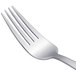 An Arcoroc stainless steel dessert fork with a silver handle.