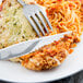 A plate of food with a Libbey Kings stainless steel dinner knife and fork.