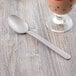 A Libbey stainless steel dessert spoon next to a glass of ice cream.