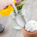 A hand holding a Libbey Farmhouse stainless steel dessert spoon over a dessert.