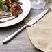 A plate of food with a Chef & Sommelier stainless steel dinner knife on it.