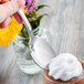 A hand holding a Libbey stainless steel dessert spoon over a chocolate dessert.