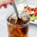 A Libbey stainless steel iced tea spoon in a glass of ice tea.