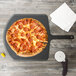 A pepperoni pizza on an Epicurean wood pizza peel next to a pizza cutter.