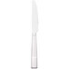 A close-up of a Libbey stainless steel dinner knife with a white handle.