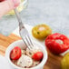 A Libbey heavy weight stainless steel cocktail fork in a bowl of mozzarella cheese and tomatoes.