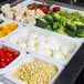 A white Cambro food pan filled with broccoli and grapes.