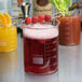 An American Metalcraft beaker glass filled with red liquid and raspberries.