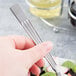 A person holding a Libbey stainless steel salad fork.