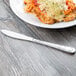 A plate of food with a Libbey Lady Astor stainless steel knife on a table.