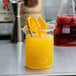 An American Metalcraft beaker glass filled with orange juice and a slice of orange.