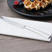 An Arcoroc stainless steel dessert knife on a plate with waffles.