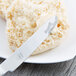 A Libbey stainless steel bread and butter knife on a plate with a biscuit.