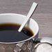 A spoon in a cup of coffee.