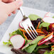 A Libbey Lady Astor stainless steel salad fork in a vegetable salad.