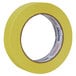A roll of yellow Duck Tape with a white background.