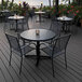 A 36-inch round black steel laminate table with a cross base, designed for outdoor or indoor use.