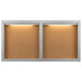An Aarco enclosed bulletin board cabinet with lights.