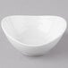 A Schonwald white porcelain dip dish with a small hole in the middle on a gray surface.