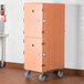 A large orange Cambro double compartment tray and sheet pan carrier on wheels.