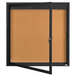 A black Aarco enclosed bulletin board with a cork interior and a glass door.