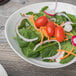 A Schonwald white porcelain bowl filled with a salad with tomatoes and carrots.