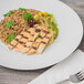 A Schonwald Grace porcelain plate with grilled chicken, rice, and vegetables on a table with a fork.