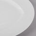 A close up of a Schonwald white porcelain plate with a white rim.