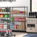 Regency black wire shelving with 4 shelves of beverages.