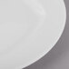 A close-up of a Schonwald Event white porcelain plate with a white rim.