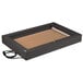 A rectangular black box with a brown surface and a cord on a table with a light on it.