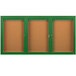 A brown rectangular cabinet with a green border and three glass doors containing cork boards.