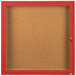 An Aarco red powder coated bulletin board cabinet with a glass door.
