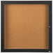 A black framed bulletin board with a key.