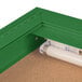 An indoor lighted green bulletin board cabinet.