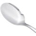 An Arcoroc stainless steel sauce spoon with a silver handle.