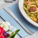 A plate of pasta with a Choice stainless steel dinner knife on a table.