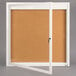 A white framed Aarco bulletin board with an open door.